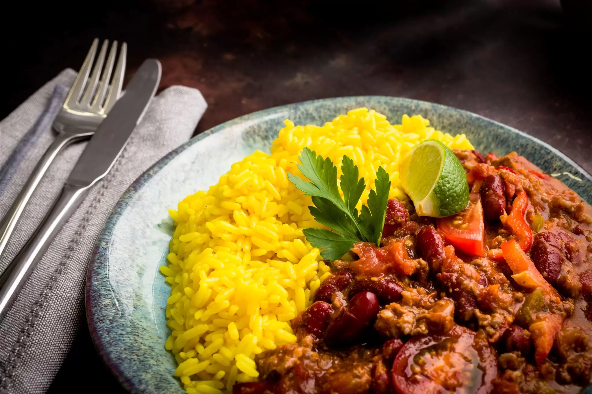 A dark, moody plate of chilli and rice